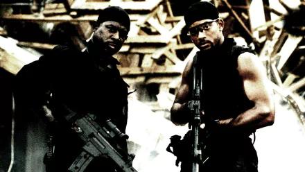 HD desktop wallpaper featuring Will Smith and a co-star from the movie Bad Boys II, both holding guns in an action-packed, gritty setting.