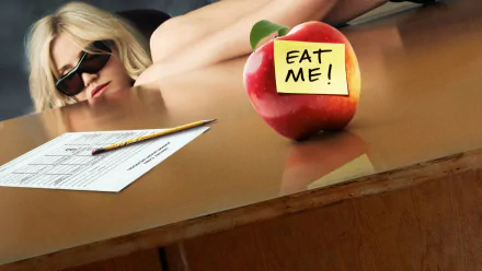 HD PC desktop wallpaper featuring Cameron Diaz from the movie Bad Teacher, showing her reclining behind a desk with an apple labeled EAT ME! in the foreground.