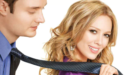 HD movie wallpaper: smiling blonde actress holding a man's tie in a promotional image for the film Beauty & the Briefcase.