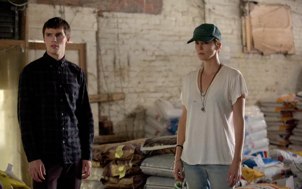 Scene from the movie Dark Places featuring Charlize Theron and another character, set in a dimly lit storage area, presented as a 4K Ultra HD PC desktop wallpaper.