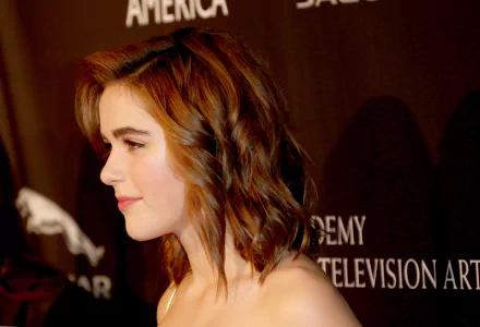 4K Ultra HD PC desktop wallpaper of a celebrity actress in profile, short wavy brown hair and bare shoulders, warm side lighting against a dark event backdrop.