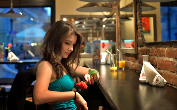 A woman in a blue dress holds a rose at a bar with a cozy, intimate mood. The image is a vibrant HD desktop wallpaper and background.