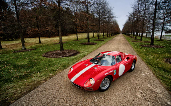 A red Ferrari 250 LM with white racing stripes parked on a tree-lined gravel road, captured in high-definition as a PC desktop wallpaper background.