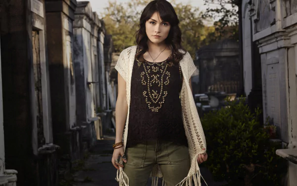 Daniella Pineda from the TV show The Originals stands confidently in a 4K Ultra HD desktop wallpaper background set in a dimly lit alley between old buildings.