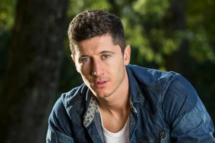 HD desktop wallpaper featuring Polish soccer player Robert Lewandowski, set against a natural outdoor background, capturing him in a casual outfit with trees in the background.