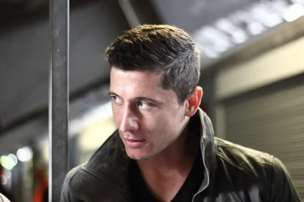 HD desktop wallpaper of Robert Lewandowski, a notable Polish soccer player, in a close-up shot with a focused expression. The background features a modern, industrial-looking setting.