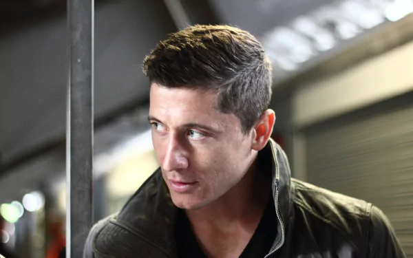 HD desktop wallpaper of Robert Lewandowski, a notable Polish soccer player, in a close-up shot with a focused expression. The background features a modern, industrial-looking setting.