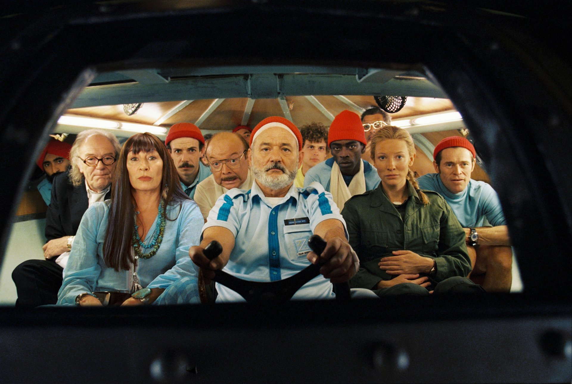 Cast of The Life Aquatic with Steve Zissou, including Cate Blanchett and Bill Murray, seated together in a colorful underwater expedition scene, 4K Ultra HD wallpaper.