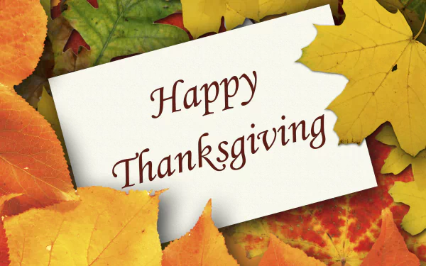 HD PC desktop wallpaper featuring colorful autumn leaves surrounding a torn paper with Happy Thanksgiving text, celebrating the Thanksgiving holiday.