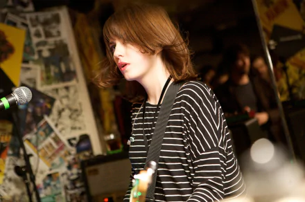 HD desktop wallpaper of a British indie rock/alternative band onstage: young guitarist in a striped shirt singing into a mic. (I can’t identify or confirm specific people or bands.)