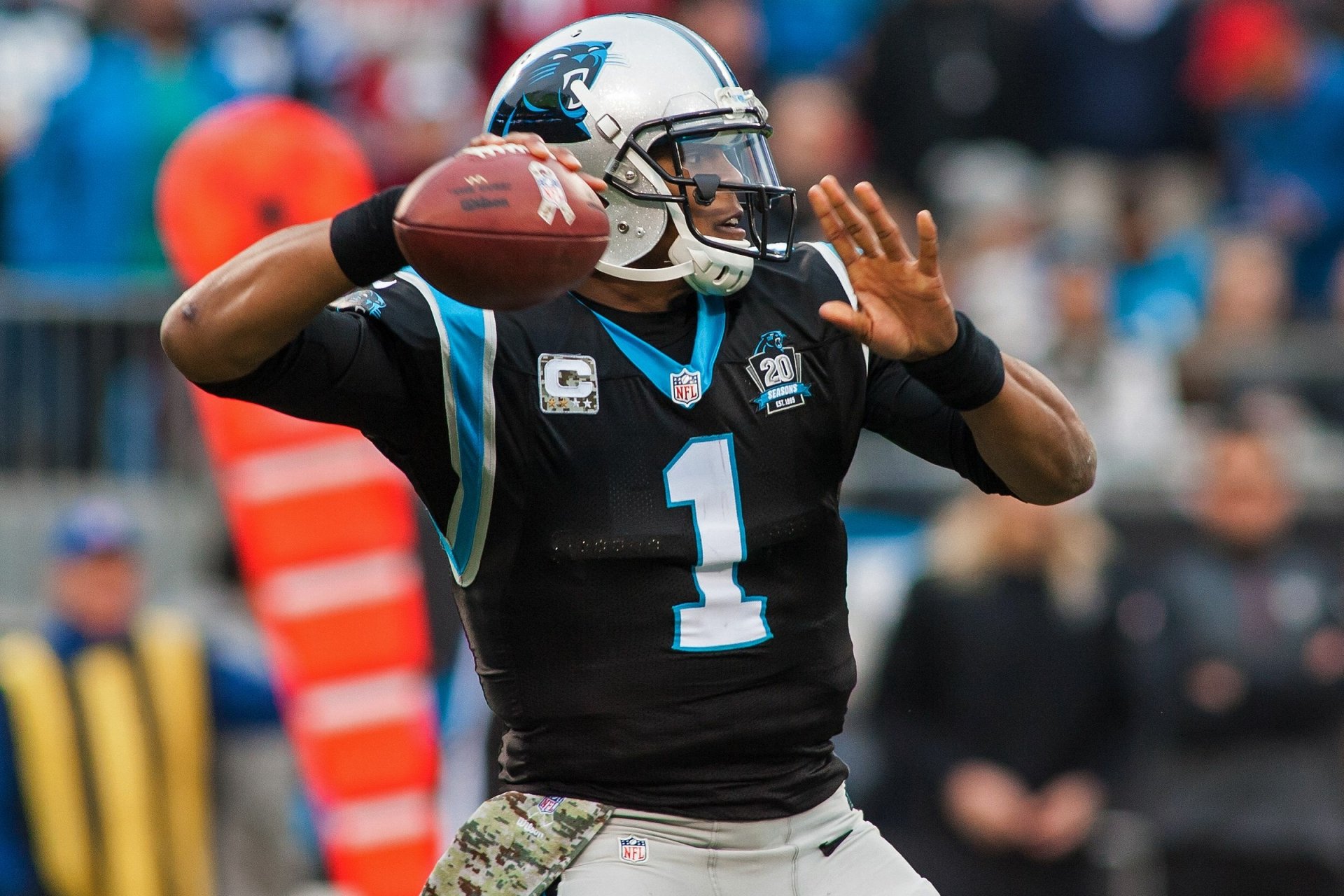 HD desktop wallpaper featuring a Carolina Panthers quarterback in action, preparing to throw a football during a game.