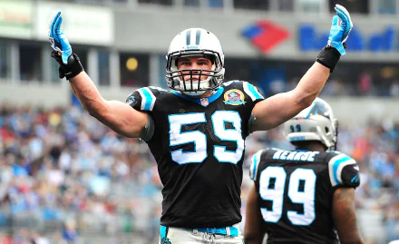 HD desktop wallpaper of a Carolina Panthers linebacker wearing #59 celebrating with arms raised on the field, team colors and a stadium crowd in the background.