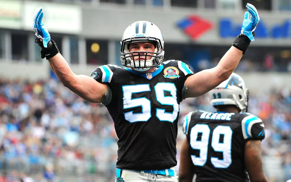 HD desktop wallpaper of a Carolina Panthers linebacker wearing #59 celebrating with arms raised on the field, team colors and a stadium crowd in the background.
