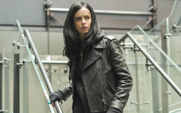 Krysten Ritter as Jessica Jones, showcasing her iconic look in a dark leather jacket, set against a modern urban backdrop in this HD wallpaper.
