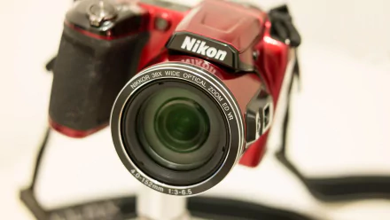 Close-up of a red Nikon camera with a wide-angle lens, showcased in 4K Ultra HD clarity as a man-made device and PC desktop wallpaper.