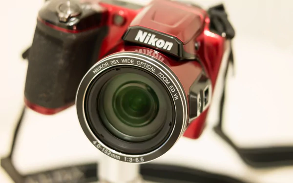 Close-up of a red Nikon camera with a wide-angle lens, showcased in 4K Ultra HD clarity as a man-made device and PC desktop wallpaper.