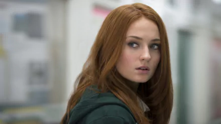 A close-up of Sophie Turner, a redhead English actress with striking blue eyes, casts a contemplative glance, making for a captivating HD desktop wallpaper.