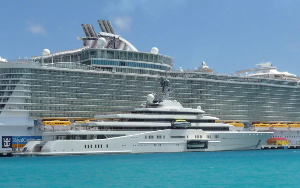 HD desktop wallpaper of the MS Allure of the Seas cruise ship docked beside a sleek white yacht on clear blue waters under a bright sky.