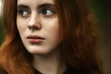 Close-up HD desktop wallpaper of a redhead woman’s face with freckles, showcasing natural beauty and soft lighting.
