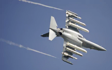 Yakovlev Yak-130 jet fighter warplane in flight with external armaments and vapor trails against a blue sky — military aircraft HD PC desktop wallpaper background.