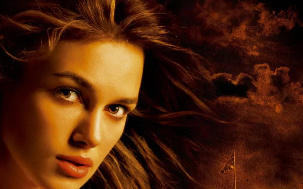 HD PC desktop wallpaper: close-up of Elizabeth Swann from Pirates of the Caribbean: The Curse of the Black Pearl, windswept hair against a stormy orange sky.