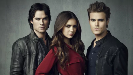A striking HD wallpaper from The Vampire Diaries, featuring the three main characters in dramatic poses, set against a muted background, capturing the show's intense atmosphere.