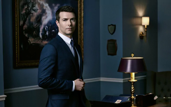 HD PC desktop wallpaper featuring a character from the TV show 12 Monkeys in a dark, elegant room with a lamp and framed artwork in the background.