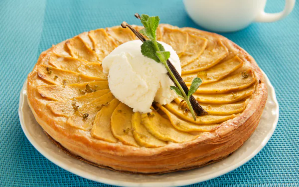5K Ultra HD desktop wallpaper: close-up of a golden baked fruit pie topped with a scoop of mint ice cream, garnished with fresh mint sprig and a vanilla bean on a plate.