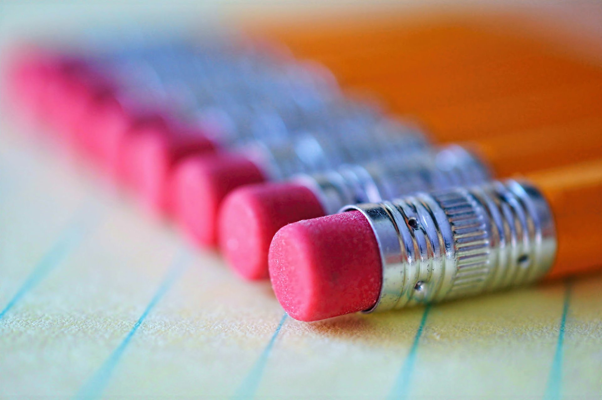 HD PC desktop wallpaper featuring a close-up, bokeh-style photograph of pencil erasers lined up on a sheet of paper.