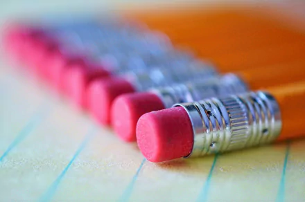 HD PC desktop wallpaper featuring a close-up, bokeh-style photograph of pencil erasers lined up on a sheet of paper.