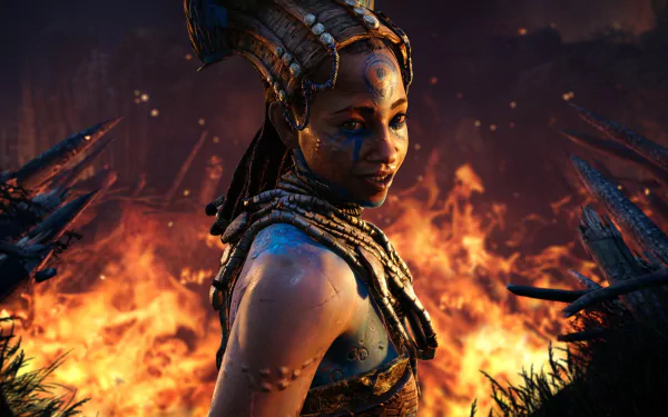 HD PC desktop wallpaper featuring a character from the video game Far Cry Primal, standing amidst flames with an intense, tribal atmosphere.
