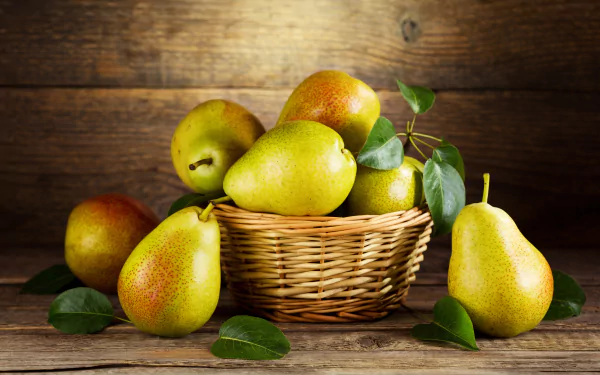 4K Ultra HD desktop wallpaper: wicker basket of ripe pears with leaves on a rustic wooden background, fruit food still life.