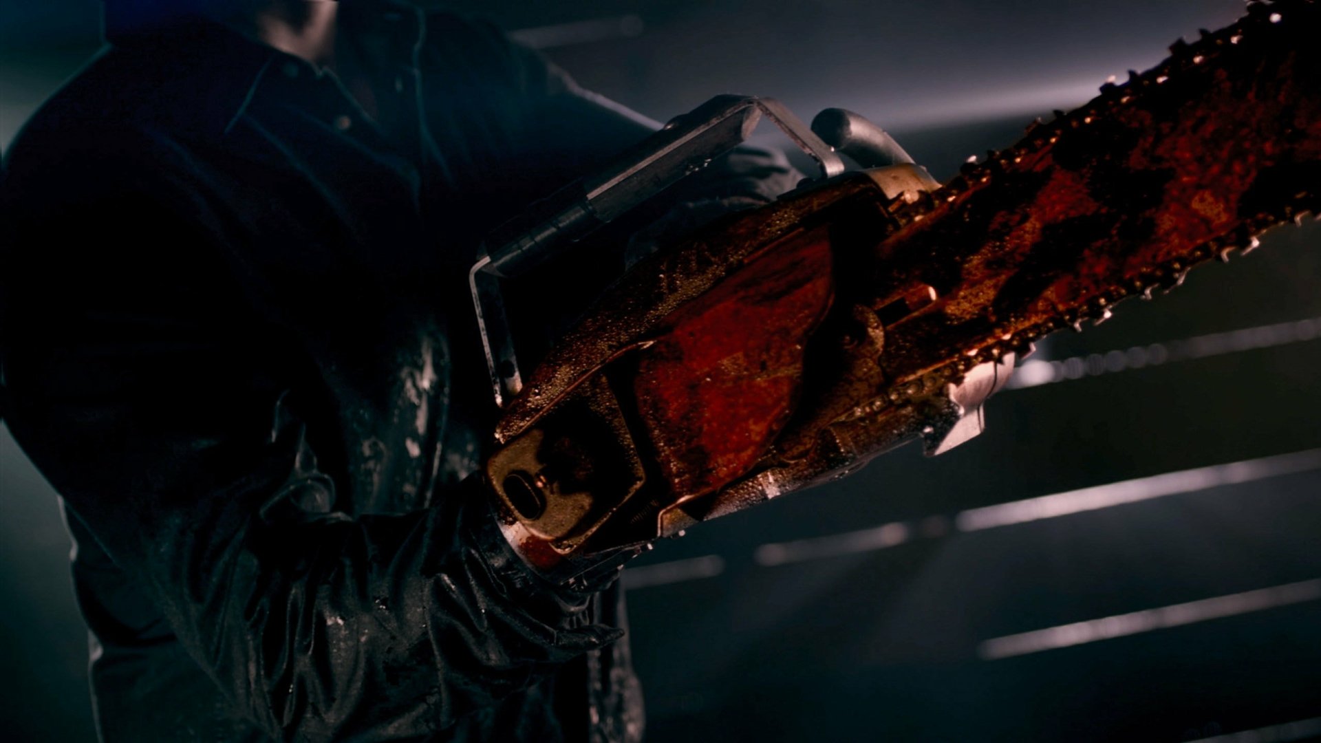 Dark 2K Quad HD PC desktop wallpaper from TV show Ash vs. Evil Dead, close-up of a blood-splattered chainsaw blade glinting in a dimly lit, grim scene.