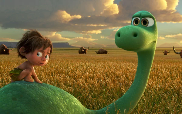 HD wallpaper from the movie The Good Dinosaur featuring a young boy and a green dinosaur in a field with cloudy skies and mountains in the background.