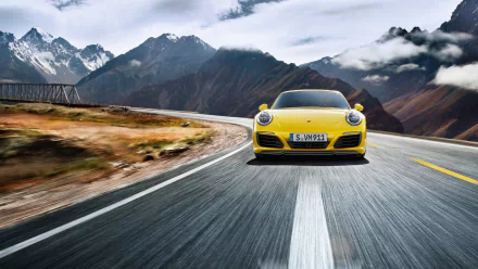 Front view of a yellow Porsche 911 Carrera 4S driving on a winding mountain road, high-resolution 2K Quad HD PC desktop wallpaper background.