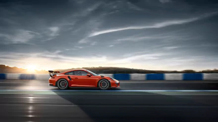 Orange Porsche 911 GT3 RS sports car speeding on a racetrack under a dramatic sky, captured in HD for a dynamic desktop wallpaper background.