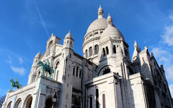 HD desktop wallpaper featuring the Sacré-Cœur Basilica in Paris, France, showcasing its religious monument and statues against a clear blue sky.