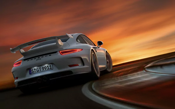 White Porsche 911 GT3 racing on a track at sunset, captured in high-definition for a PC desktop wallpaper background.