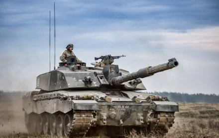 HD desktop wallpaper featuring a Challenger 2 military tank positioned in a field under a cloudy sky.