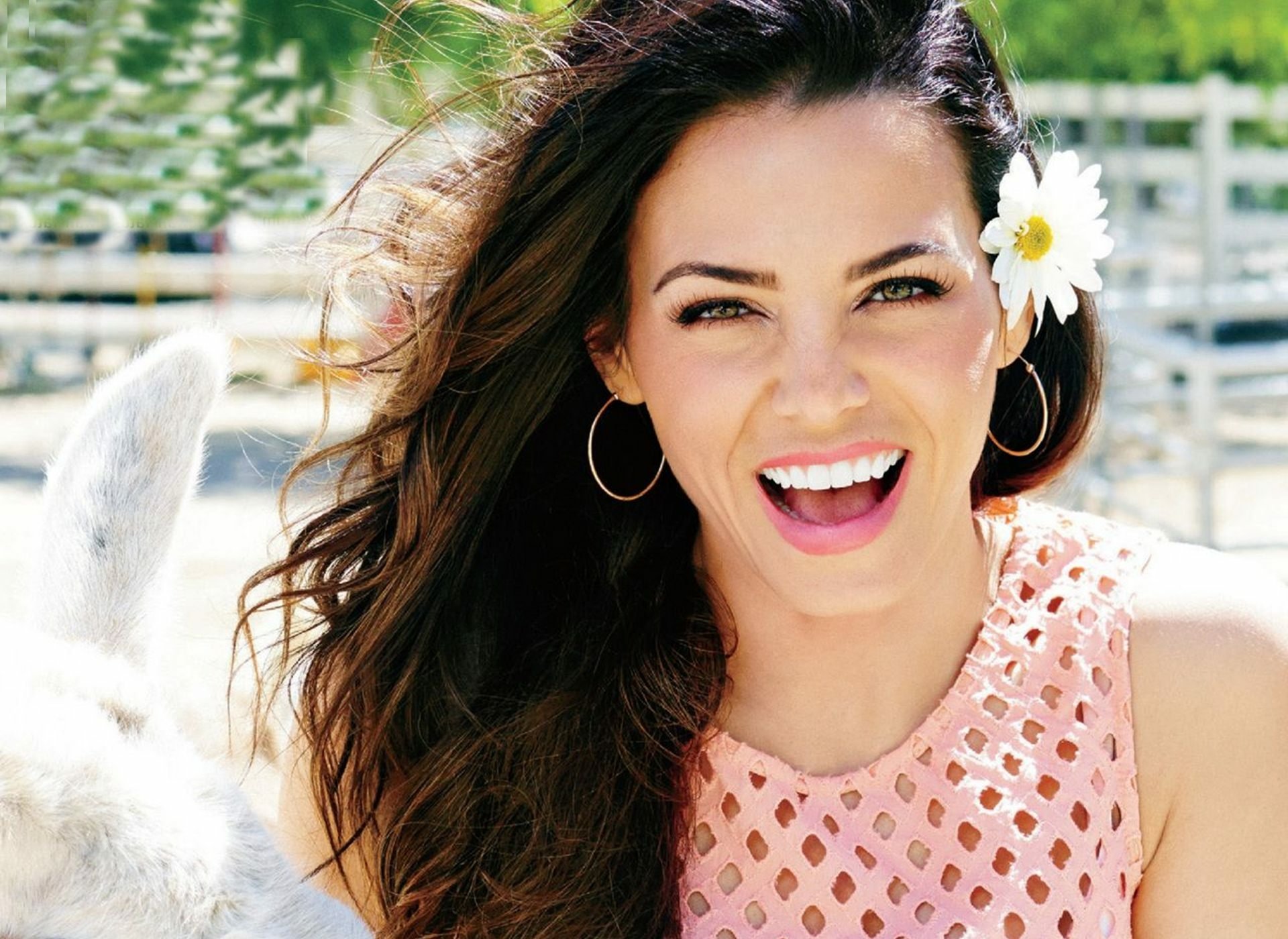 HD desktop wallpaper of American actress Jenna Dewan with brunette hair, green eyes, and a bright smile, wearing hoop earrings and a flower in her hair.