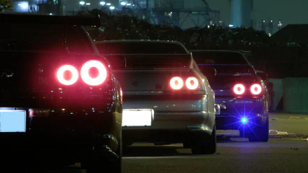 HD desktop wallpaper featuring the rear view of three JDM cars at night with illuminated tail lights.