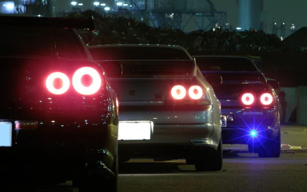 HD desktop wallpaper featuring the rear view of three JDM cars at night with illuminated tail lights.