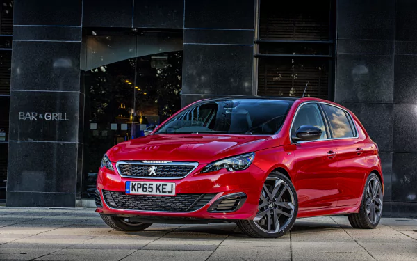A red Peugeot 308 compact car parked in front of a modern building, showcased in 4K Ultra HD as a high-quality PC desktop wallpaper and background.