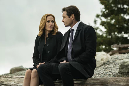 Gillian Anderson as Dana Scully and David Duchovny as Fox Mulder from The X-Files sit outdoors, captured in a 4K Ultra HD PC desktop wallpaper.