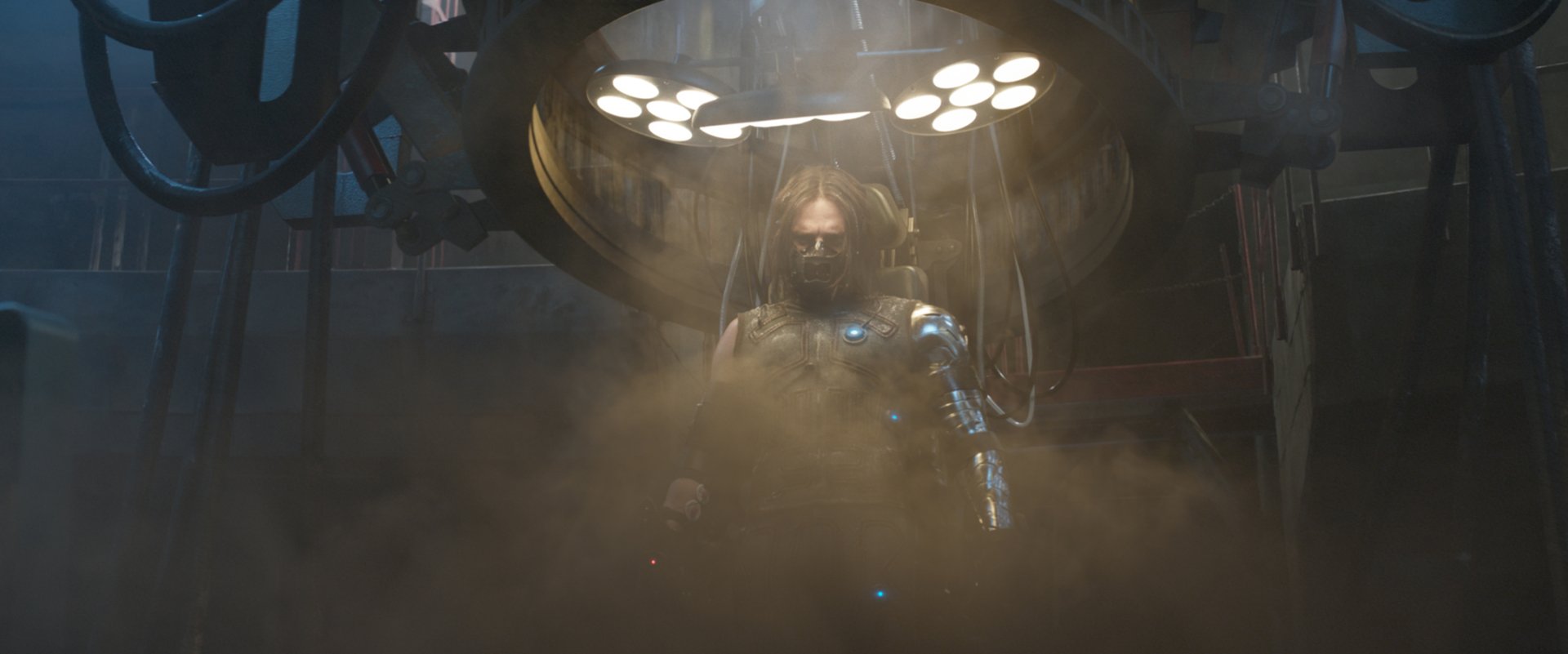 Sebastian Stan as the Winter Soldier emerges from a shadowy chamber, enveloped in mist and dramatic lighting, captured from the movie Captain America: Civil War.
