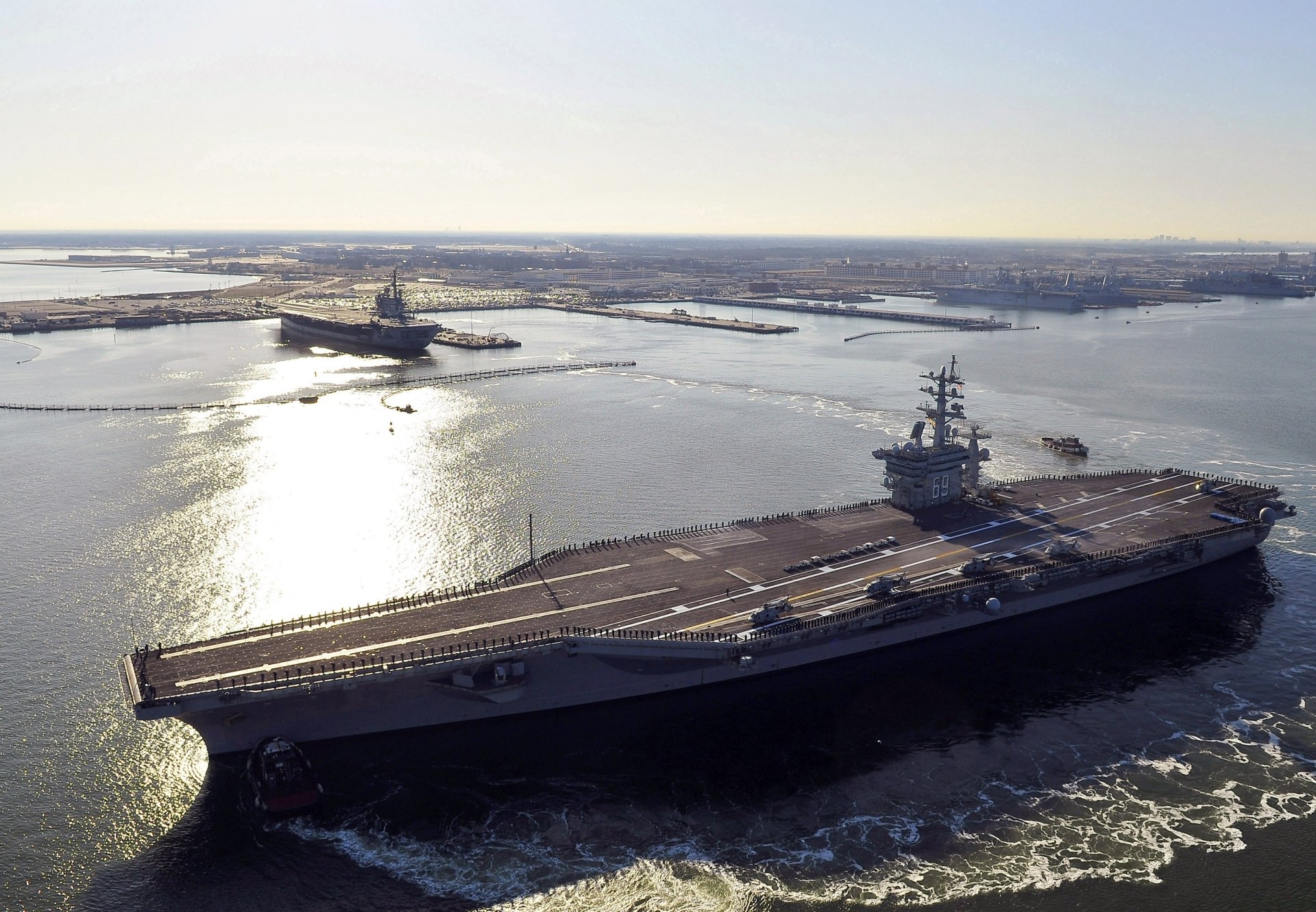 Aerial view of the USS Dwight D. Eisenhower (CVN-69) aircraft carrier at sea, showcasing the warship and navy operations in clear daylight.