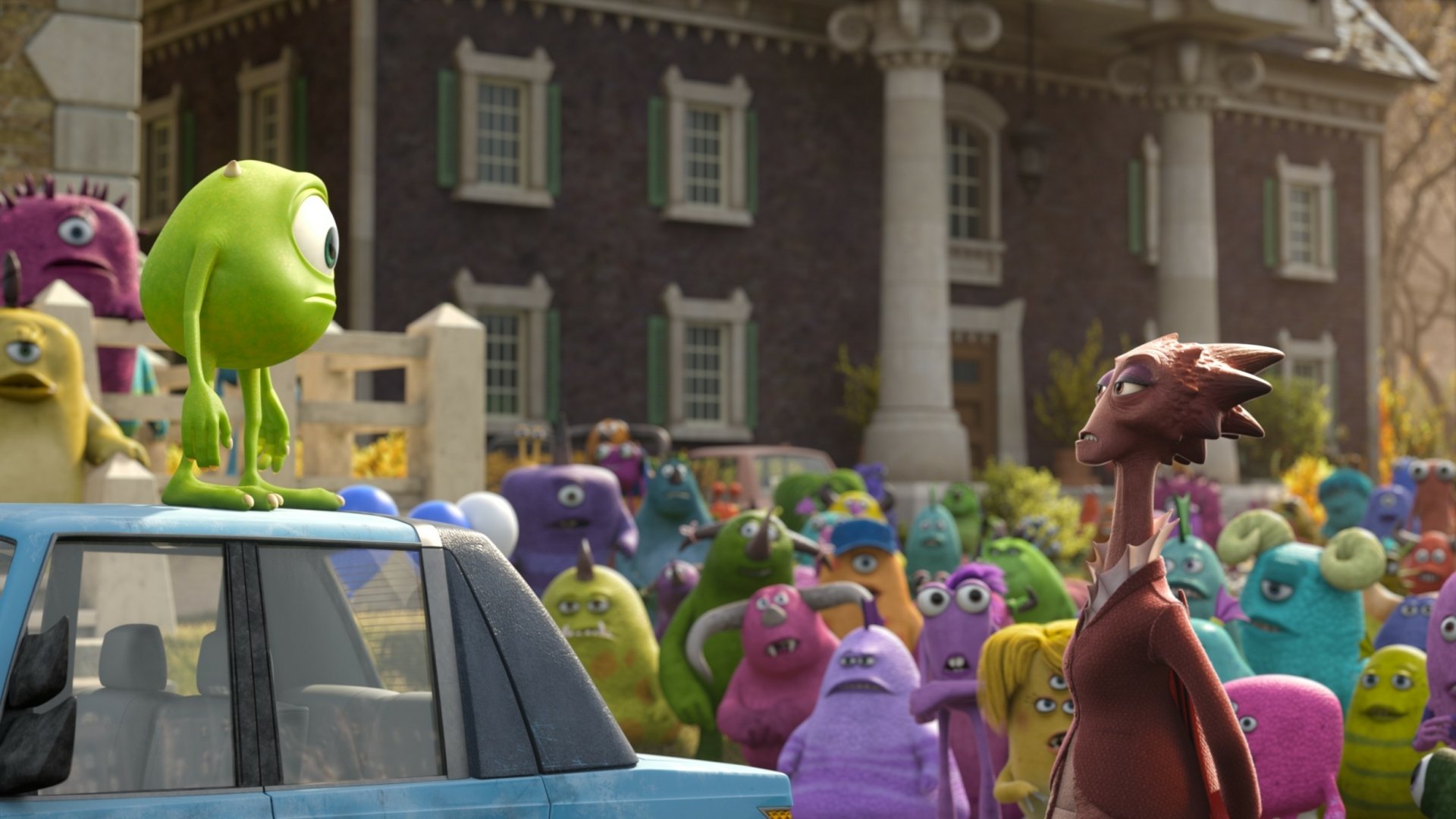 HD PC desktop wallpaper from the movie Monsters University: Mike Wazowski stands on a car roof facing Dean Hardscrabble as a crowd of colorful monsters gathers.