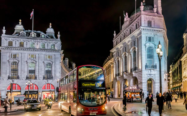A vibrant London street scene at night features a red double-decker bus passing iconic buildings, illuminated by city lights, showcasing the architectural beauty of England.