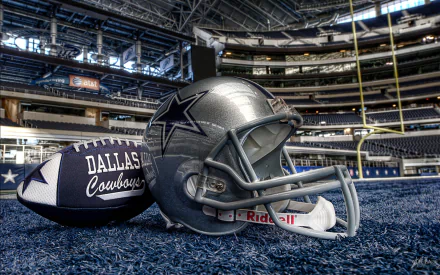 A striking HD desktop wallpaper featuring a Dallas Cowboys helmet and football, set against the backdrop of an empty stadium, capturing the essence of sports and team spirit.