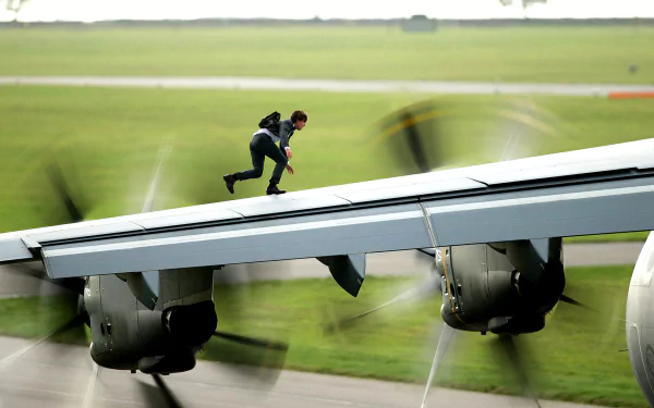 A dynamic scene from *Mission: Impossible - Rogue Nation*, featuring a character scaling the wing of a plane, capturing the thrill and intensity of the film in this striking HD wallpaper.